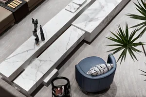 A modern living room featuring marble elements and a blue armchair.