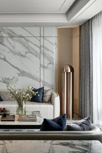 Modern living room featuring a white marble wall and floor, minimalist furniture, and contemporary decor.