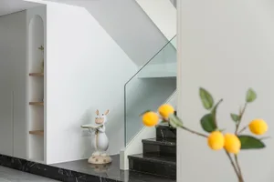 Modern minimalist staircase featuring marble steps and railings with glass railings.