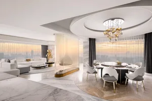 A modern residential interior featuring marble finishes, sleek furniture, and a circular dining table with gold accents.