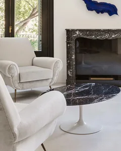 A modern white living room with a marble fireplace and coffee table.
