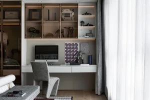 A minimalist home office with a sleek desk, modern chair, and organized shelf.