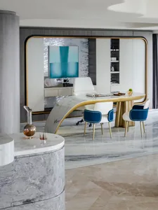 Modern home office with glass desk and chairs, white walls, and a white chair.