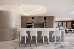 A modern kitchen with white marble countertops and wooden cabinets