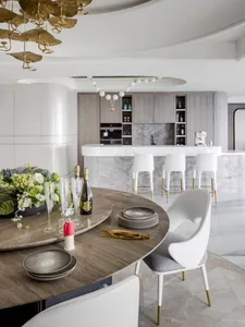 Modern kitchen featuring marble countertops, white cabinetry, and high-end appliances.