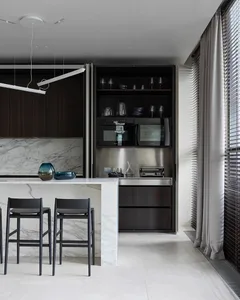 Contemporary kitchen featuring marble countertops and dark wood cabinets.