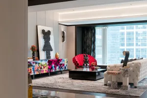 A modern living room with a colorful sideboard, a white sofa, and a black coffee table.