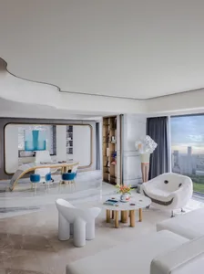 A modern living room with marble flooring, minimalist furniture, and a cityscape view through large windows.