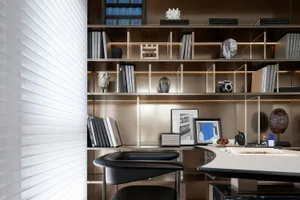 A modern office space featuring metallic shelves and a sleek desk with books and other office items.