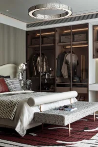 A modern bedroom featuring a white bed with textured fabric bedding, a wooden bench, and a metallic robot sculpture.