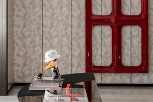 A decorative figurine holding a yellow tube on a book stack placed on a terrazzo floor.