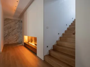 Modern interior design featuring a staircase, fireplace, and suite.