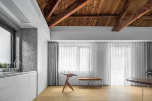 Contemporary living room with wooden furnishings, glass windows, and concrete accents.