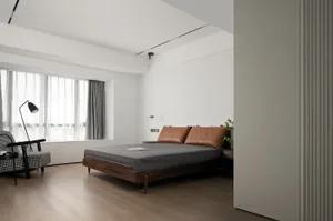 A minimalist bedroom featuring a wooden bed frame, leather headboard, and glass window with sheer curtains.