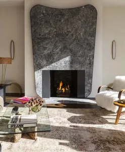 A minimalist interior design featuring a marble fireplace and contemporary furniture.