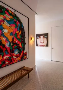 A modern art collection featuring abstract and figurative pieces in a contemporary space.