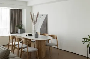 Modern living room featuring a marble and wooden dining table, wooden chairs with grey cushions, and abstract art on the wall