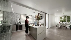 A modern kitchen with marble countertops and stainless steel appliances.