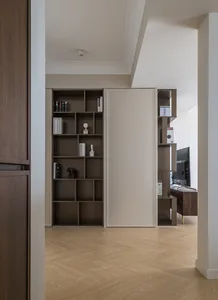 Modern living room with built-in storage shelves and a combination of wood and metal materials