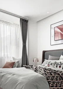 A minimalist bedroom featuring grey furniture and fabric bedding.