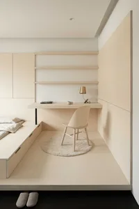 A minimalist bedroom with a wooden chair, desk, and wooden shelves.