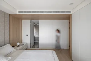 A minimalist bedroom with white furniture, wooden paneling, and a marble floor artery