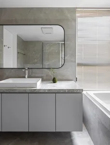 Modern bathroom with marble countertop and white sink.