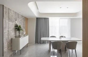 Modern dining room with marble table and chairs, featuring sleek lines and a minimalist design.