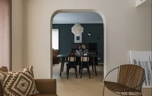 Modern dining room featuring wooden furniture and a decorative light fixture.