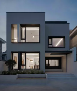 Modern residential home with concrete and glass exterior in twilight setting.