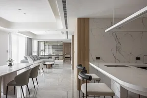 Modern kitchen featuring marble and concrete materials with a bar counter, chairs, and a cozy seating area.