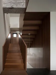 Modern wooden staircase with dark wood flooring and a glass partition for privacy.