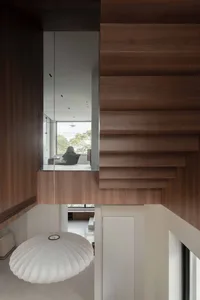 Modern residential staircase with wooden steps and railings.