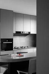 Modern kitchen with minimalist design, featuring concrete countertops and white cabinets.
