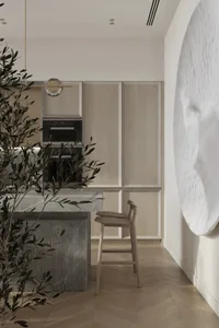 A modern minimalist kitchen with a white color scheme, featuring wood cabinets and a marble countertop. Includes a bar stool 