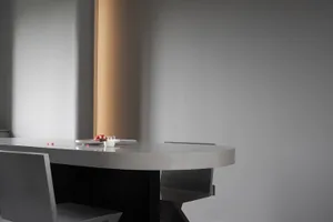 Minimalist interior design featuring a sleek, concrete countertop and a single glass drink container.