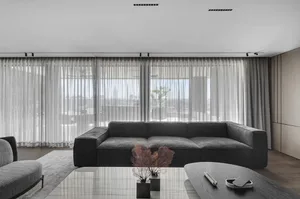 Minimalist living room featuring a textured canvas sofa and wooden table.