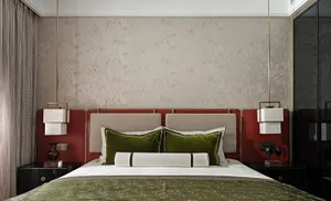 A modern bedroom featuring a velvet headboard and plush bedding.