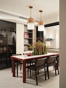 Modern dining room with marble table, wooden chairs, glass decorations, and metal accents.