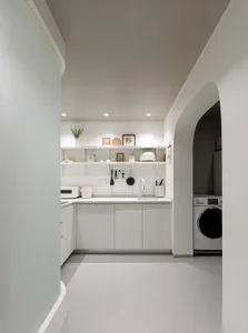 Minimalist kitchen with white cabinets and modern appliances.