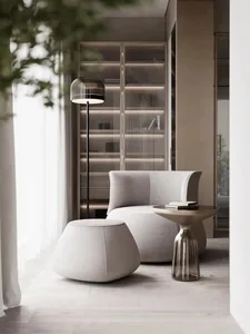 Modern living room with sleek, minimalist furniture, including a white upholstered chair, matching ottoman, and glass table.