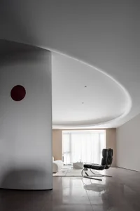 A modern minimalist living room with white walls, a sleek black chair, and large windows.