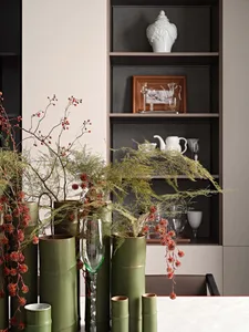 Still life arrangement featuring ceramic vases and greenery in an urban residential setting.