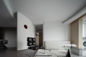 A modern living room with glass, cement, and white leather materials.