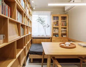 簡約臥室內擺放全木質家具與大型書架。