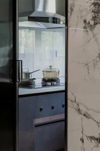 Modern kitchen featuring marble countertops and backsplash.