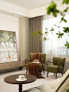 A modern living room with green armchairs, a round wooden table, and a large window covered with sheer curtains and a beige c