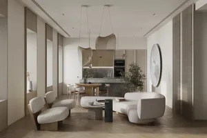 A modern minimalist living room with white furniture, a curved sofa, a coffee table, and a kitchen area in the background.