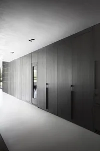 A modern minimalist bathroom with dark wooden cabinets and a white floor.