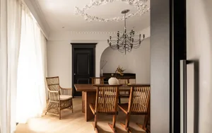 Modern minimalist dining room featuring wooden furniture and canvas accents